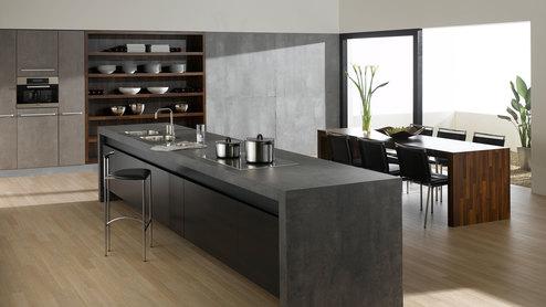 Küchen- und Esszimmerimpression mit einer Kombination aus Holz- und Stein-/ Betonoptik und Einbauschränken