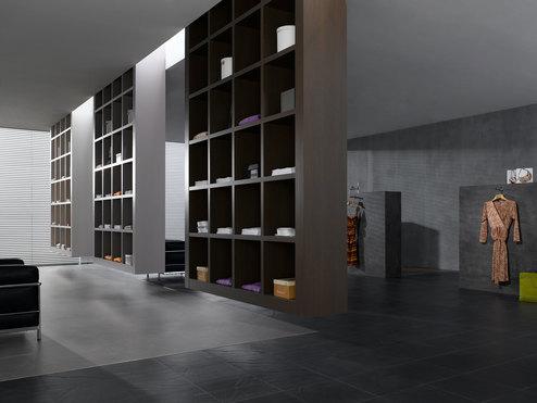 Impression eines geräumigen Regalsystems aus dunklem Holz in einem hochwertigen Bekleidungsladen