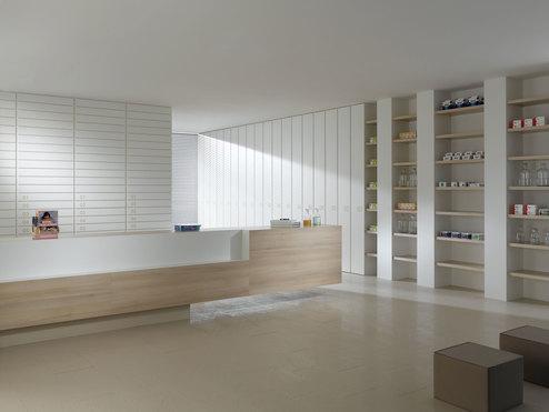 Impressionen einer Apothekeneinrichtung mit hellen Holzmöbeln und geräumigem Regalsystem, sowie aufgeräumten Empfang.